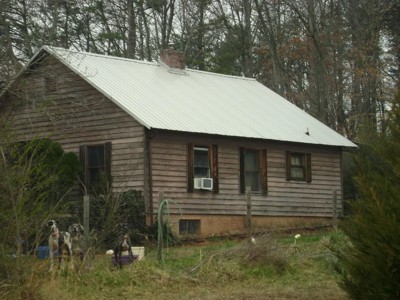 White metal roof on an old wood sided farmhouse, from a Metal Roof Installation job in Valley Center